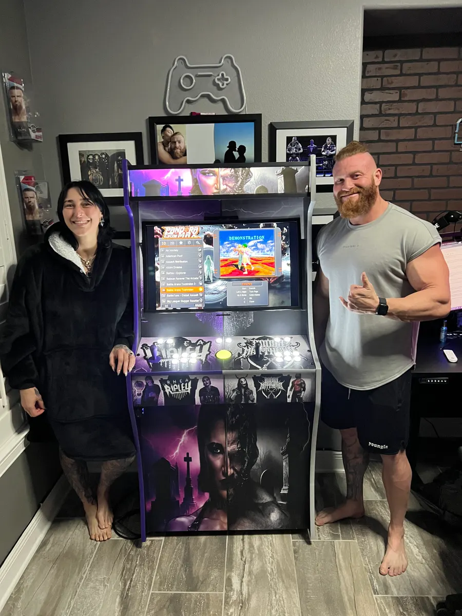 Rhea Ripley & Buddy Matthews with the finished Dark Union arcade